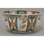An Imari bowl, c.1800, enamelled and gilt with panels of feathers, fruit and flowers, the interior