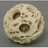 A Canton carved ivory puzzle ball, c.1870, approximately twelve finely pierced layers, the outer