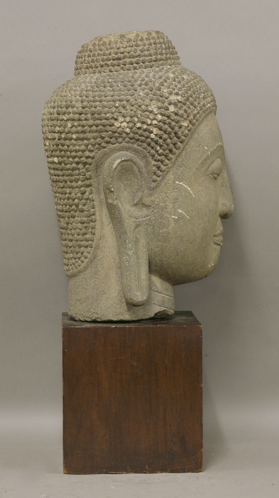 A carved stone bust of Buddha,19th century or later, serenely modelled, on a wood block base,bust - Image 3 of 3