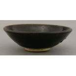 A black-glazed Tea Bowl, Song dynasty (960-1279), of shallow form, the mirror black glaze pulling