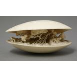 An ivory Shell Dream,late 19th century, the part opened bivalve enclosing three men under pine trees