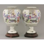 A pair of porcelain lanterns and stands, 20th century, each globe enamelled with a grumpy
