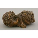 An attractive bamboo Carving,mid 19th century, of two shishi squabbling in a ring over a brocade