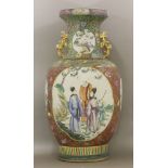 A large famille rose vase, c.1900, painted with shaped panels of figures in naturalistic landscape