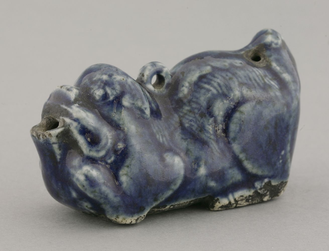 A porcelain blue glaze Water Dropper,18th century, in the form of a reclining Buddhist lion, the
