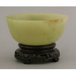 A jade bowl, 20th century, the stone of a grey-green tone, 10.9cm, wood stand (2)