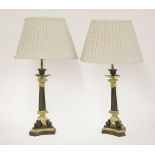 A pair of gilt bronze candlesticks,of triform outline, now converted for electricity, with pleated