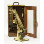 A lacquered brass monocular microscope,with extra lenses and accessories,34cm,in a mahogany and