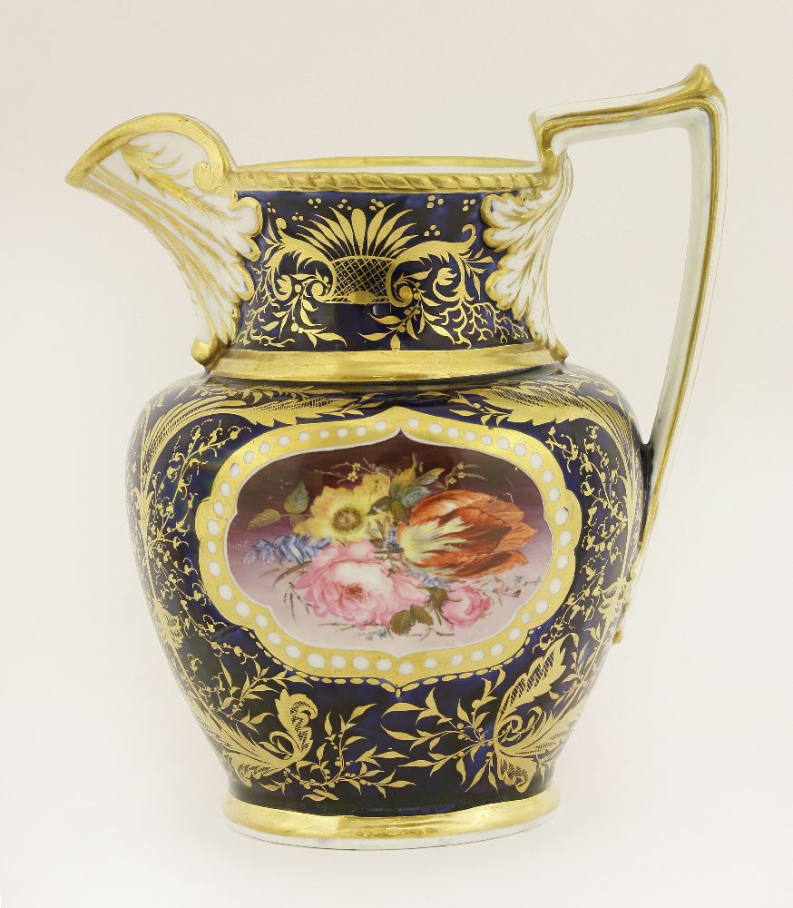 A Coalport hand-painted jug, c.1810, with panels of flowers within a shaped gilt cartouche against a