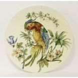 A large French pottery hand-painted charger,dated 1884, painted with a parrot on a fruiting branch