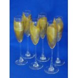 A set of six glass Flutes, each individually decorated with gold leaf,