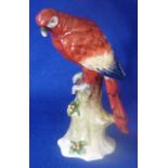 An early 20th Century hand decorated Continental porcelain Model of a Parrot perched on a tree