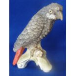 A 20th Century hand decorated Goebel porcelain Model of an African Grey Parrot perched upon a leafy