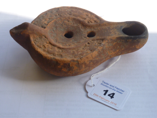 A Roman style red terracotta Oil Lamp of predominantly circular section,