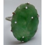 A ladies 9 carat white gold Dress Ring centrally mounted with an oval jadeite carving of fruits