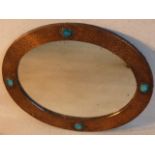 An early 20th Century oval copper framed wall hanging Looking Glass in Liberty's style,