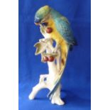 A porcelain Model of a yellow breasted Macaw decorated in polychrome on a fruiting branch with