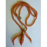 A coral bead Necklace with a triple elongated shape coral Pendant on a yellow gold suspension