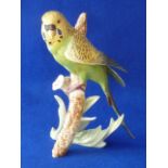 Goebels A porcelain Model of a green Budgerigar perched on a branch with applied hand crafted