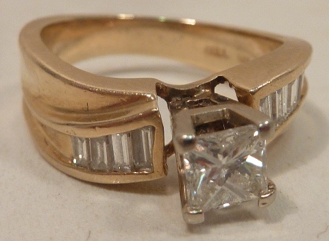 A 14 carat gold Ring half carat princess cut diamond centre with baguette diamond shoulders