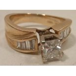 A 14 carat gold Ring half carat princess cut diamond centre with baguette diamond shoulders
