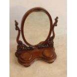 An elaborate 19th Century oval mahogany Swing Mirror,