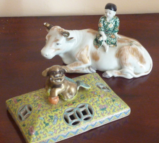 A late 19th Century Chinese porcelain model of a young boy seated upon the back of a recumbent ox