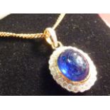 A cabouchon sapphire and diamond Pendant on a 9 carat gold Chain CONDITION REPORT: