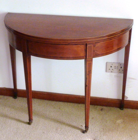 A George III period bow fronted mahogany and boxwood strung fold over top Tea Table raised on