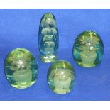 Four 19th Century green glass Dumps each with internal flower head design,