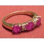A 9 carat gold ladies Ring set with three rubies and four small diamonds