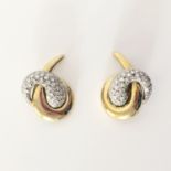 PAIRE DE CLIPS D'OREILLES. NOEUD DE RUBAN En or 18K d edeux tons rehaussé de diamants ronds en serti