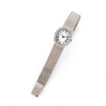 ƒƒ ANNEES 1960. MONTRE DE DAME. en or gris 18K. Boitier ovale entouré de diamants taille brillant en