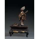 OKIMONO SIGNÉ MIYAO ZOen bronze de patine brune et rehauts de dorure, représentant une joueuse de