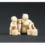 * SHUNGA NETSUKE DE DAMEen ivoire, représentant une femme à la toilette en compagnie de son enfant