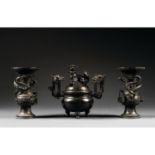 GARNITURE D'AUTEL EN TROIS PIÈCESen bronze de patine sombre, composée d'un brûle-parfum tripode