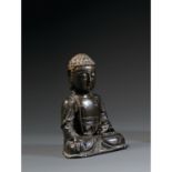 STATUETTE DE BOUDDHAen bronze de patine sombre, assis en vajrasana, la main droite en