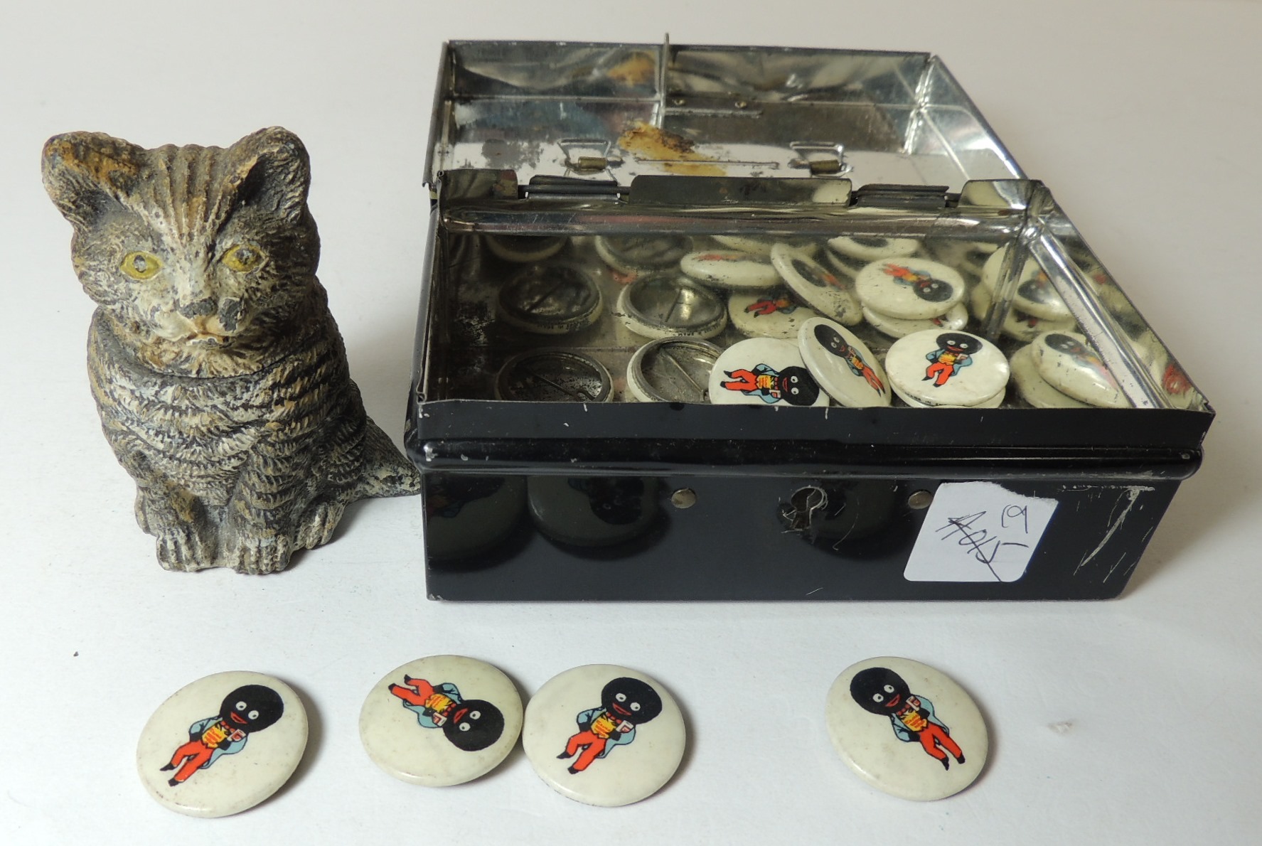 Twenty Robertsons Golly badges and a cold painted spelter cat inkwell, in a tin money box