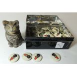 Twenty Robertsons Golly badges and a cold painted spelter cat inkwell, in a tin money box