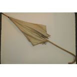 A Victorian parasol with long cane handle, cream cotton canopy with braid decoration, 94cms long