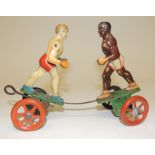 A German early 20th Century tinplate clockwork toy of two boxers, mounted on wheels with coloured