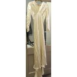 A 1930's ivory satin wedding dress and slip; the dress close fitting with buttons to the back,
