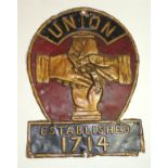 A 19th Century embossed tin fire mark "Union Established 1714" centred with clasped hands, with