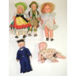 A hollow celluloid clockwork crawling baby with original printed cotton clothing, 10cms high; a