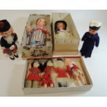 Four small celluloid dolls with sleeping glass eyes and in costume; a slightly larger celluloid