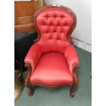 A Victorian mahogany button back armchair, serpentine front rail, scroll arm rest and on ball feet