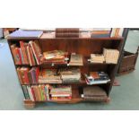 A stained pine three shelf bookcase of narrow form and with shaped apron to base