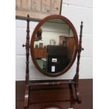 An early 19th Century oval toilet mirror, on slender turned supports and with boxwood line inlay.