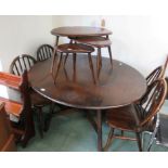 An Ercol dark wood dropleaf dining table with four Ercol hoop back dining chairs