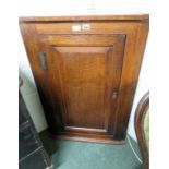 A Georgian oak corner cabinet, single bevelled panel door enclosing three fitted shelves